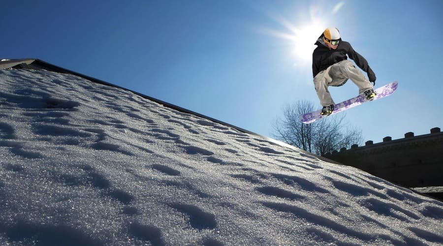 un ragazzo che salta sullo snowboard