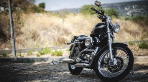 una moto nera parcheggiata su una strada in primo piano di fornte