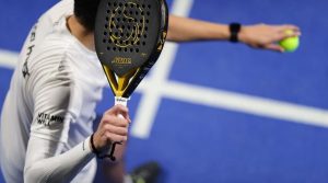 un giocatore di padel di spalle con la racchetta in primo piano