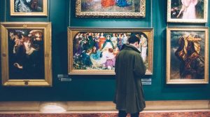 un uomo di spalle ad una mostra di quadri