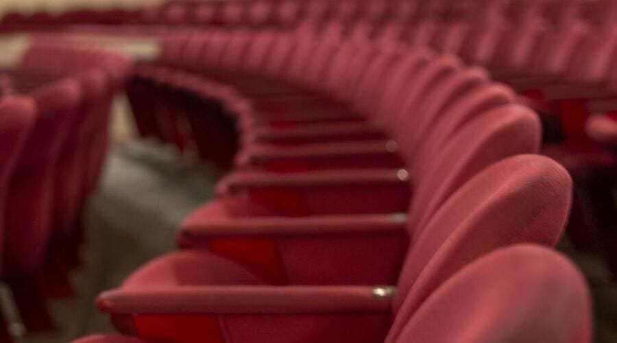 una fila di poltrone rosse da teatro