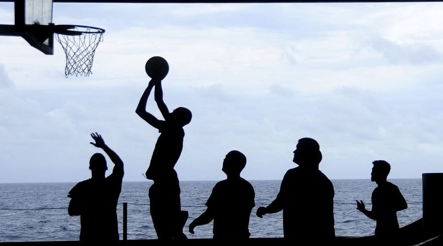 un gruppo di ragazzi in controluce che gioca a basket